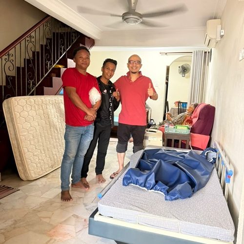 Three men and a hospital bed in a home, possibly for elderly care.
