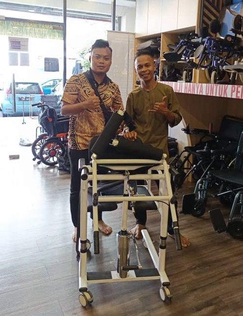 Two men stand by a stand-aid lift, showcasing mobility equipment.