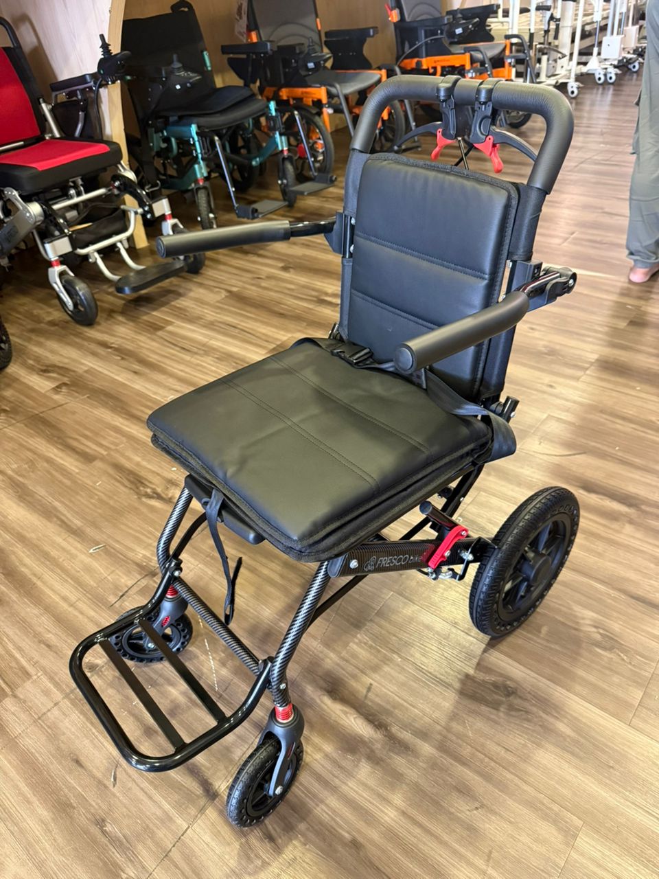 Black Fresco Bike travel wheelchair, lightweight and portable, ideal for elderly.