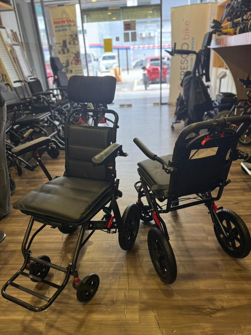 Two black Fresco Bike travel wheelchairs, lightweight and foldable, shown in a store.