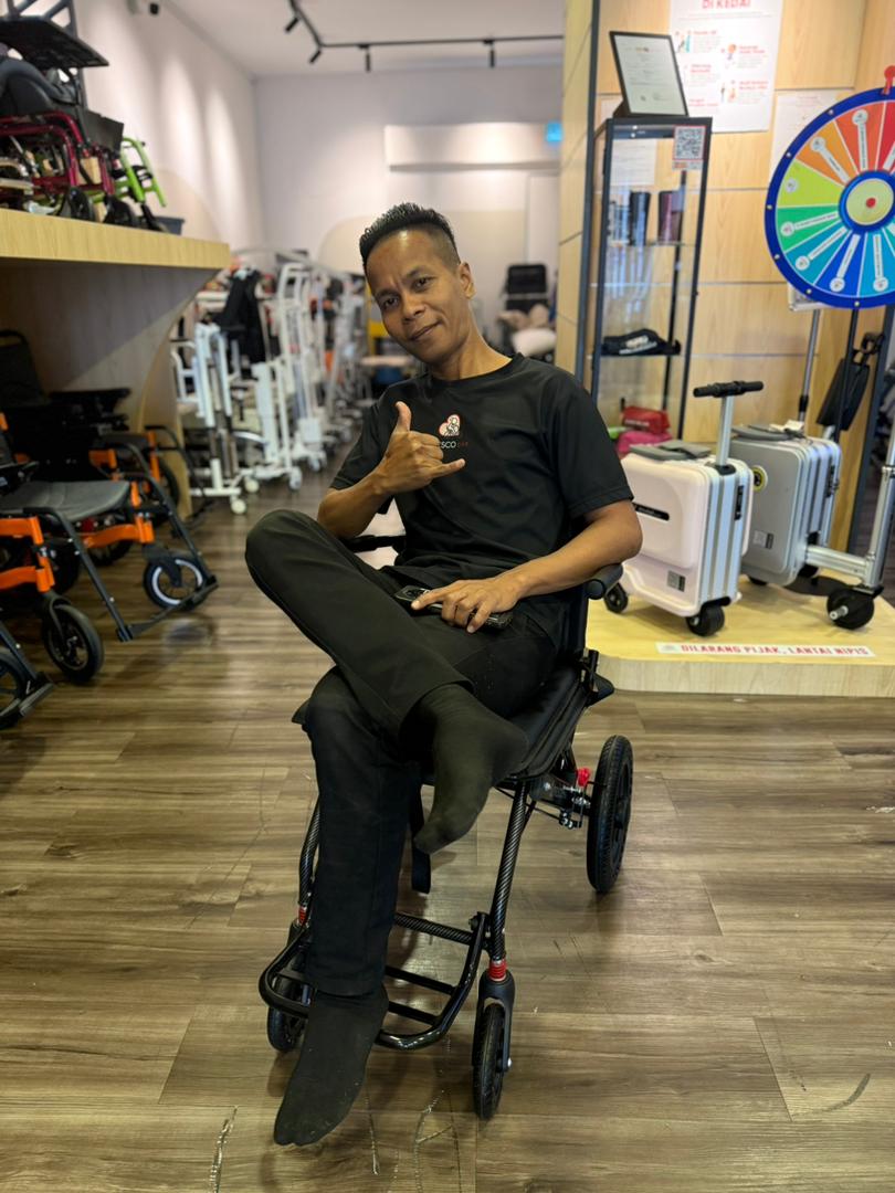Man smiling in a lightweight Fresco Bike travel wheelchair.