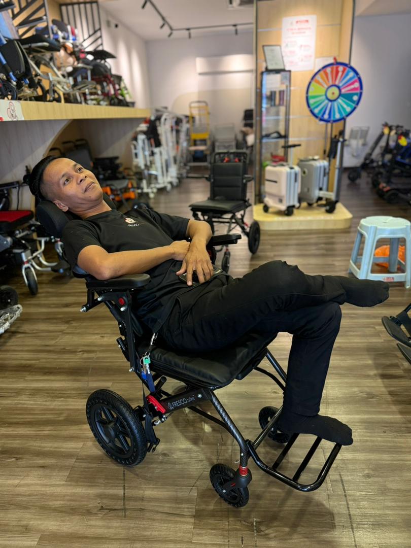 Man relaxing in a Fresco Bike travel wheelchair. Lightweight and portable design.